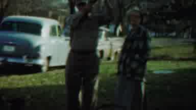Saint Francis Kansas (1959): Man Wearing Tan Shirt Looks Up At Tree On A Sunny Day