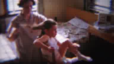 South Bend Indiana (1958): Woman Brushes Her Daughter's Hair As Daughter Squirms
