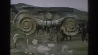 Ephesus Turkey (1962): Man Wearing Dark Grey Uniform Stands In Front Of Orange And