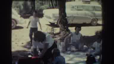 RHODES GREECE-1962: Family Picnic In Park With Classic Cars And Coastal Road Scene