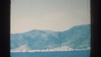 Rhodes Greece-1962: Sailing On A Wooden Ship In Calm Seas Past An Island Or Peninsula