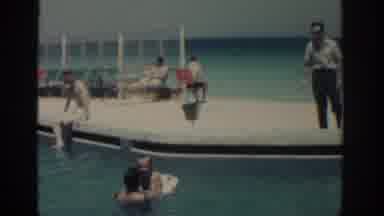 RHODES GREECE-1962: Boy Wearing Red Shorts Climbs Onto White Platform From Water