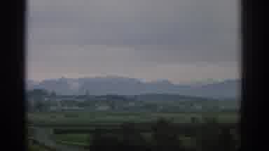 ZURICH SWIZTERLAND-1963: View Of Mountains And Green Fields On A Cloudy Day
