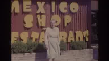 Florida USA (1962): Old Lady Standing In Front Of Billboards With Flowing Dress