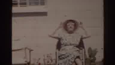 Florida USA (1962): Woman Wearing White Hat Sits In Red Wheelchair On A Sunny Day
