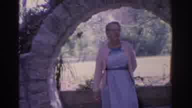 Florida USA (1962): Mature Woman Looking Around In Front Of Stone Wall And View Of