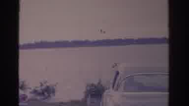 Florida USA (1962): Grainy View Of Kiddos Motoring on A Lake With Vintage Cars In