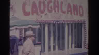 Florida USA (1962): Man Smoking Pipe Near A Laugh-Land Inside Of A Circus