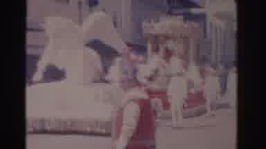 Florida USA (1962): A Person In A Large Mask Waving At A Man During A Large Parade