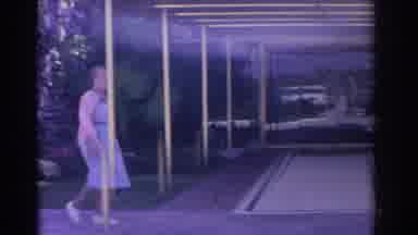 Florida USA (1962): Woman Wearing Blue Dress Walks Towards Camera On A Bright