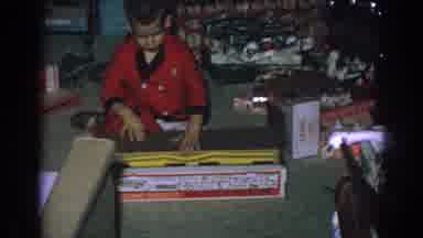 Gary Indiana (1962): Little Boy In Red Pajamas Opens A Toy Racetrack In Front Of A