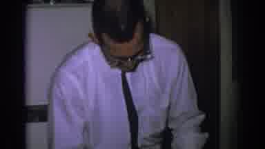 Gary Indiana (1962): Man In A White Shirt Tie And Apron Prepares To Spoon