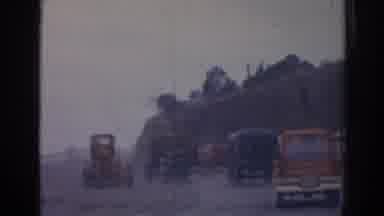 Izmir Turkey (1962): View Of Buses And Orange Tractor On Dirt Road On A Clear Day