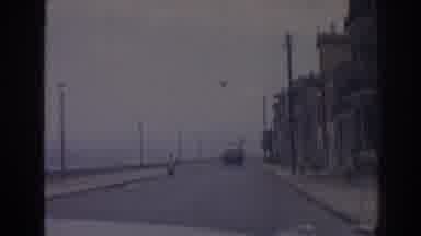 Izmir Turkey (1962): Scooter Driving By Shoreline And Cars And People On A Busy