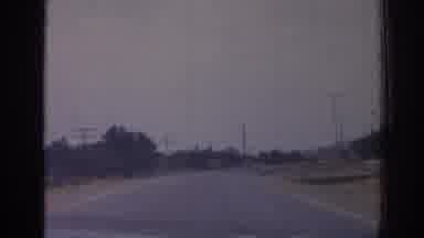 Izmir Turkey (1962): Car Driving Down Road People Crossing Houses Pylons Passing