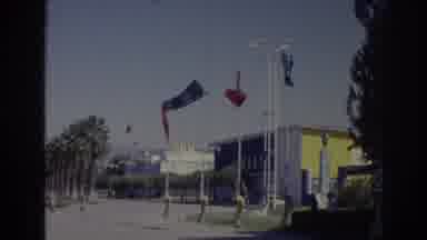 Izmir Turkey (1962): Multiple Flags Being Flown On Poles Outside Building