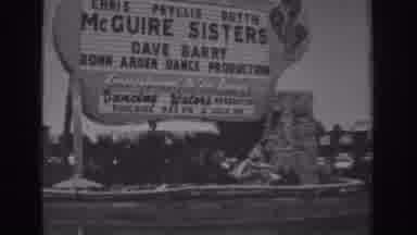 Las Vegas (1962): People Walk By The Sign That Says McGuire Sisters And To A