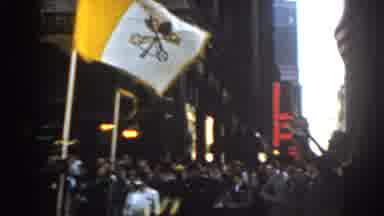New York City (1962): People In A Street Parade Raising A Flag That Says Ancient