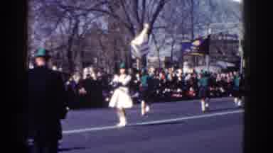 New York City (1962): Many People Watching A Street Parade And A Woman Holding A