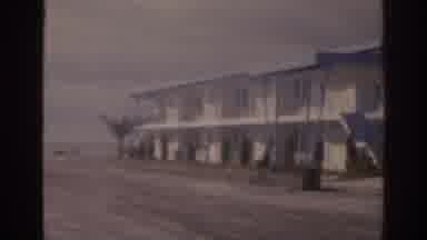 Florida USA (1963): Two White Cars Parked Next To White Building On A Cloudy Day