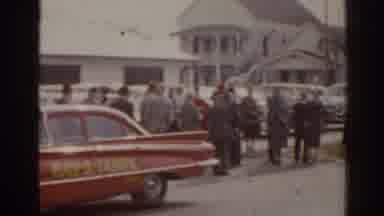 Florida USA (1963): People Wearing Grey Uniforms Stand Between Red Car And White