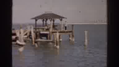Florida USA (1963): A Person Stands On A Wooden Dock With A Roof And Stares Across