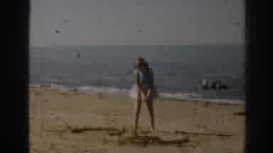 New Jersey USA (1963): Girl Plays With Sand On The Beach While Mother Watches From