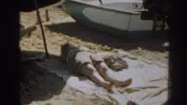 New Jersey USA (1963): A Person Laying On A Towel At The Beach And A Woman Looking