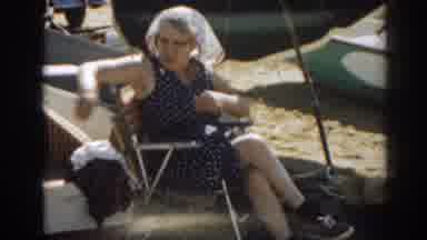 New Jersey USA (1963): Woman Wearing Black Romper Sits In Yellow Chair At Beach On