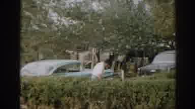 New Jersey USA-1963: Man Gardening in Backyard with Classic Cars and Laundry Line