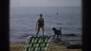 New Jersey USA (1963): Two Women On Beach Enjoying Day With Their Dog Clear Sky
