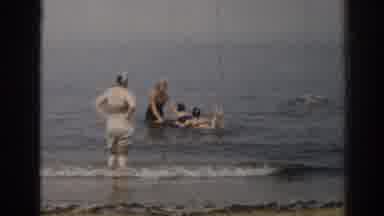 New Jersey USA (1963): Woman Wearing White Shorts Stands In Seawater At Beach On A