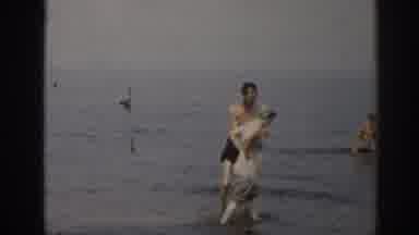 New Jersey USA (1963): Family Walking And Playing In The Ocean And Woman Walks By