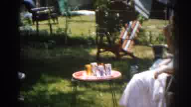 New Jersey USA (1963): Three People Sitting Outside With Drinks While Fourth Does