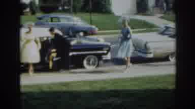 New Jersey USA (1963): Women In Formal Wear On Sidewalk As Man Helps Another Woman