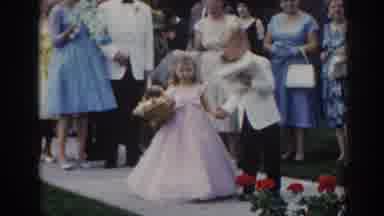 New Jersey USA (1963): Woman Wearing Green Dress Holds Hat In Place On A Clear