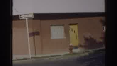 New Jersey USA (1963): A Building With A Yellow Door And Two People Walking