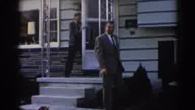 New Jersey USA (1963): Elder Going Outside While Man Casually Wales Down The