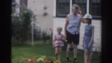 New Jersey USA (1963): Woman Wearing White Shirt Carries White Cake Towards House