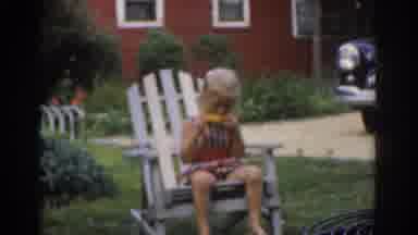 New Jersey USA (1963): Woman Wearing Sleeveless Blouse Watches Sitting Young Boy