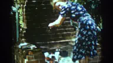 Auburn California (1939): Woman In Blue And White Dress Cooks Over An Outdoor