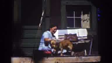 Lake Tahoe California (1939): Women In A Blue Dress Outside Of A House Wiping A