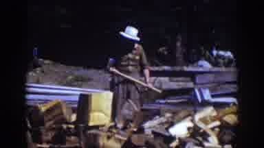 Lake Tahoe California (1939): Man Wearing White Hat Chops Wood With Ax On A Sunny