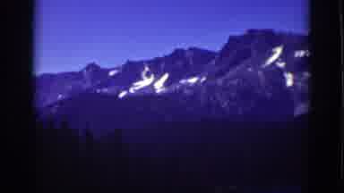 Lake Tahoe California (1939): Sun Gazed Snow Clad Mountains With A Lush Green