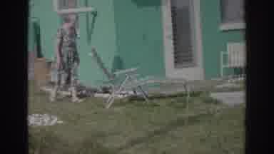 Norfolk Virginia (1966): Woman Wearing Sundress Walks In Her Yard Next To Her