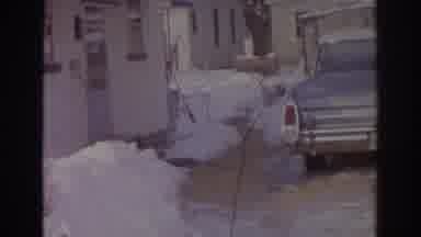 Norfolk Virginia (1966): View Of Blue Car Parked In Front Of Small Tan Building On