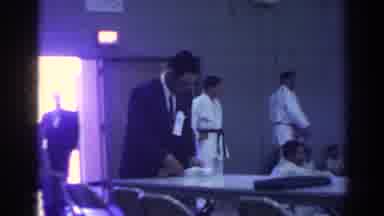 Temple City California (1966): Man Wearing Grey Suit Looks A Small Slip Of Paper