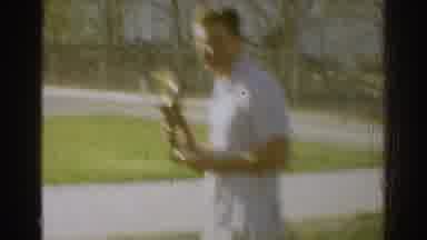 West Covina California (1966): Man Wearing White Shirt Holds Small Gold Trophy On