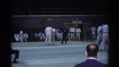 Los Angeles California (1967): Man Wearing Grey Suit Watches Karate Match In