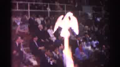 Los Angeles California (1967): Person Holds Gold Eagle Symbol Banner During Indoor